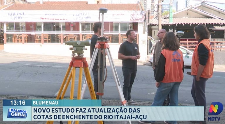 Survey team with surveying equipment and tripod conducting a study on river elevation in Blumenau, Brazil